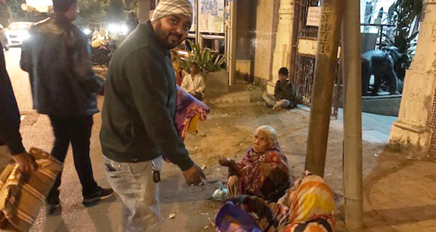 employees distributing blankets to the underprivileged in a community outreach