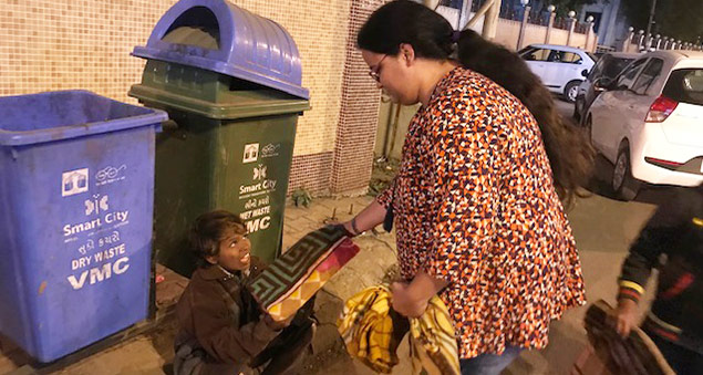 employees distributing blankets to the underprivileged in a community outreach