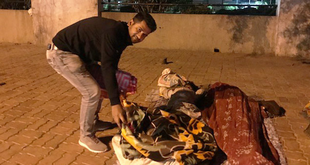 employees distributing blankets to the underprivileged in a community outreach