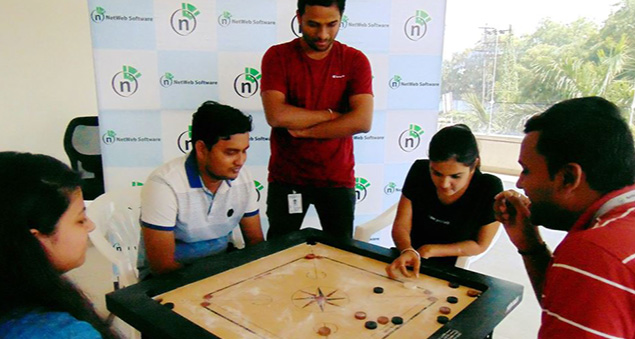 employees enjoying an indoor carrom tournament with team spirit