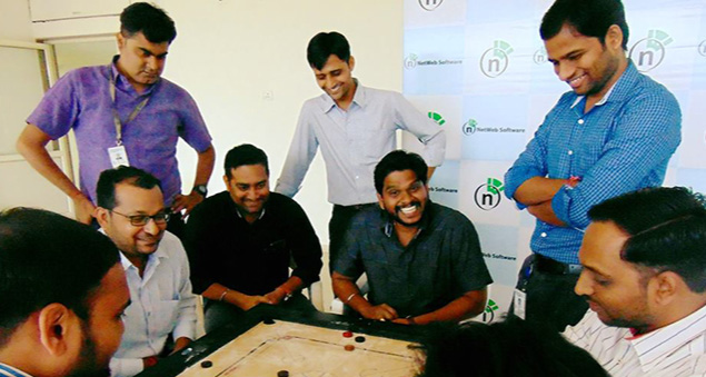 employees enjoying an indoor carrom tournament with team spirit