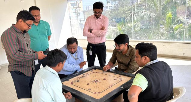 team members playing competitive indoor carrom tournament in 2022